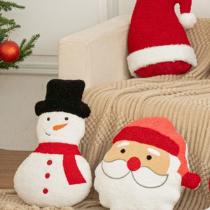 Festive Christmas snowman and Santa Claus plush pillows on a cozy sofa setting