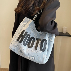 Blue paisley canvas tote bag with metal chain strap and black letter detail