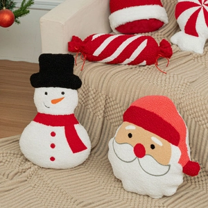 Detailed plush texture of Santa and snowman pillows on a beige knit blanket