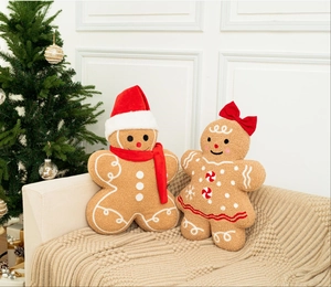Detail view of plush gingerbread man pillows with Christmas hats on a cozy sofa