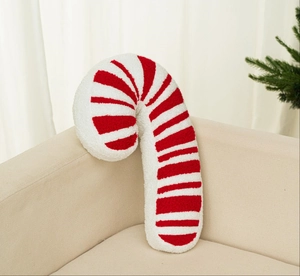 Detalle de la textura del cojín con forma de bastón de caramelo rojo y blanco en un sofá