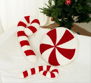 Close-up of plush candy cane and peppermint pillows with soft red and white stripe fabric