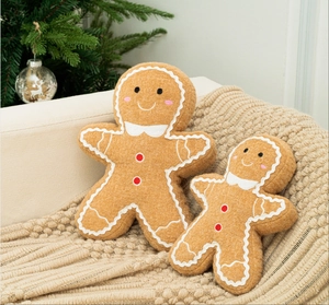 Détail de deux coussins en peluche bonhomme de pain d'épices sur un canapé de Noël