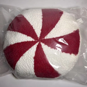 Detail of round peppermint candy plush pillow with red and white spiral stripe texture