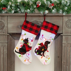 LED lighted Christmas stockings set with buffalo plaid cat and dog motifs on wooden mantle