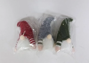 Three Christmas gnomes in packaging with knitted hats and white beards in red, grey, green