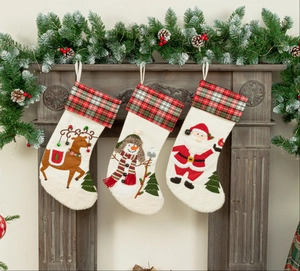 Detailed close-up of Santa, Snowman and Reindeer Christmas stockings on a wooden mantel