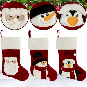 Three Christmas velvet stockings with Santa, snowman and penguin cartoon characters