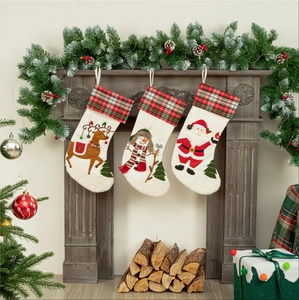 Three Christmas stockings with Santa, Snowman and Reindeer patterns hanging on a fireplace
