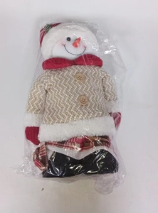 Dettaglio di un pupazzo di neve natalizio in peluche con cappello rosso e maglione a maglia