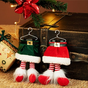 Paire de suspensions d'elfes de Noël en peluche sur fond festif de sapin et cadeaux