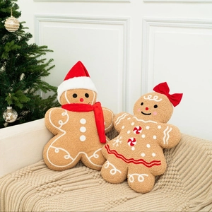 Gingerbread man plush pillows with Christmas hats on cozy sofa with festive tree