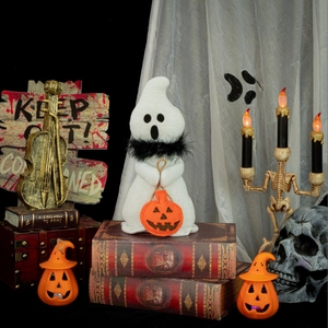 Knitted Halloween ghost doll on vintage books with a mini pumpkin and feather collar