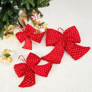 Festive red Christmas bows with gold patterns on a white faux fur background