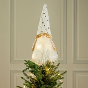 Close-up of lighted Christmas tree topper gnome with gold snowflake sequins and white fur
