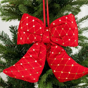 Red velvet Christmas bow with gold diamond embroidery and sequins on a pine tree