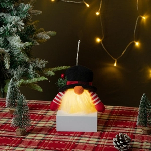 Lighted Christmas gnome ornament with tall black hat and glowing beard on festive table
