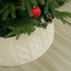 Detailed close-up of cream knitted Christmas tree skirt with textured diamond pattern