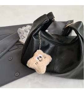 Detail of black semi-moon hobo bag in textured PU leather with cute plush star charm