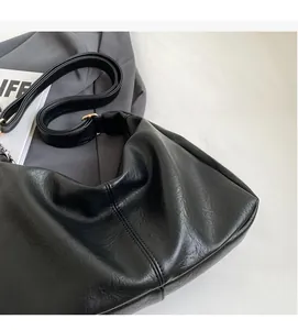 Detail of black tote bag showing premium PU leather texture and soft pleated design