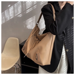 Detail view of large leather tote bag with rivets and fringes for women commuting