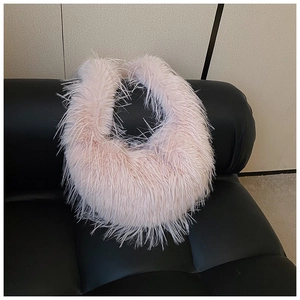 Détail du sac à main pelucheux rose en forme de lune avec texture douce en plumes