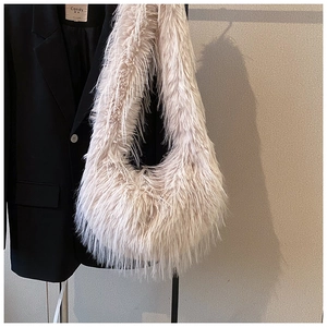 Détail de la texture d'un sac en fausse fourrure sur fond de blazer noir élégant