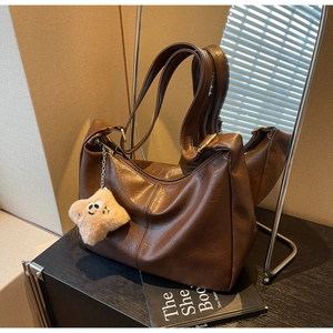 Detail of dark brown hobo tote bag featuring a cute plush star charm and smooth PU texture
