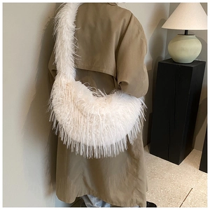 Vue détaillée d'un sac bandoulière en fausse fourrure blanche sur un mannequin en trench