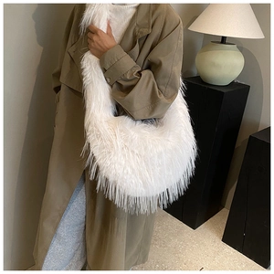 Détail d'un sac demi-lune blanc en fausse fourrure douce avec texture dense