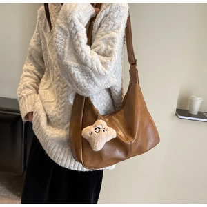 Detailed texture of brown faux leather hobo bag with a plush star charm detail