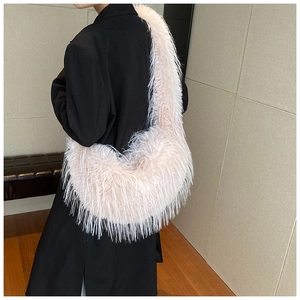 Détail de la texture en fausse fourrure rose clair sur un grand sac à bandoulière d'hiver