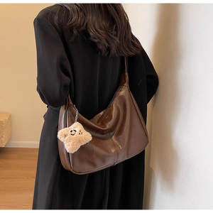 Detail of retro brown leather hobo bag with a plush star charm and stitching