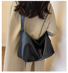 Détail d'un grand sac hobo noir en similicuir souple avec une texture de cuir plissé