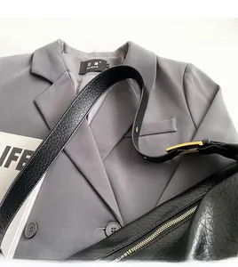Détail de la texture cuir grainé avec boucle dorée et fermeture éclair de qualité