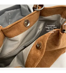 Macro view of brown tote bag featuring invisible magnetic closure and herringbone lining