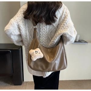 Retro brown leather dumpling bag with star pendant shown on model in knitwear