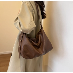 Sac cabas en cuir marron vue latérale sur mannequin dans un intérieur minimaliste
