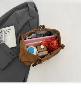 Top view of spacious brown corduroy tote bag interior with daily essentials and tablet