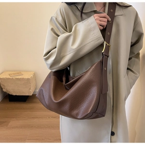 Détail du grand sac cabas en cuir marron foncé avec texture grainée et bandoulière réglable