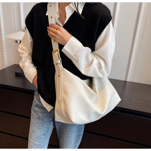 Détails du cuir grainé blanc et de la boucle dorée sur le grand sac hobo