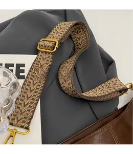 Detail of adjustable woven wide shoulder strap with retro geometric pattern and bronze clasp