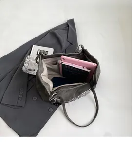 Detail showing spacious interior compartment and chain strap of this grey tote bag