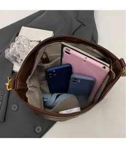 Interior view of brown leather tote bag showing large capacity for laptop and umbrella