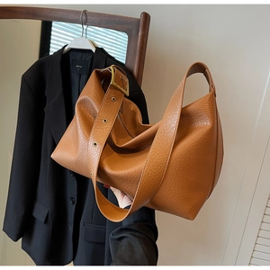 Détail d'un sac cabas marron en cuir grainé avec boucle en métal doré ajustable