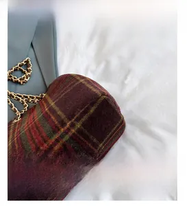Close-up of vintage plaid fabric texture and fine stitching on a chain bucket bag