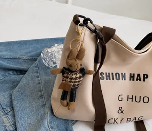 Nahaufnahme eines handgefertigten Hasenanhängers mit Hahnentrittweste an einer Stofftasche