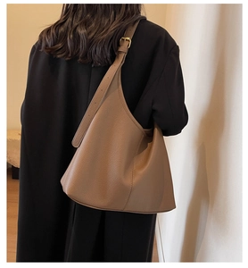 Detail of soft brown pebble leather texture and adjustable strap on large tote bag