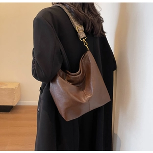 Detail of the vintage floral wide strap and gold hardware on the brown leather hobo bag