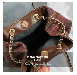 Detail view of the secure golden magnetic snap closure on vintage plaid wool bag